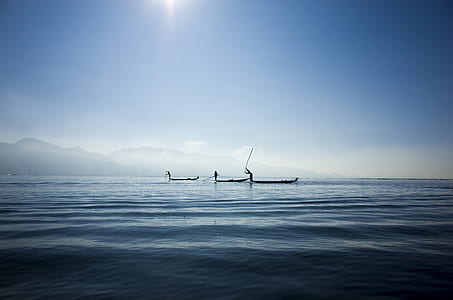 three people on boats on body of water thumbnail