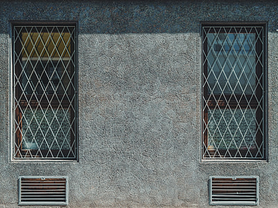 gray concrete building with window with grill and vent thumbnail