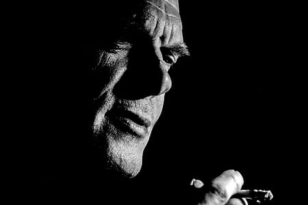 man holding cigarette stick photo thumbnail