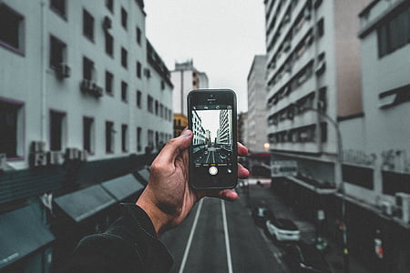 person holding phone taking photo thumbnail