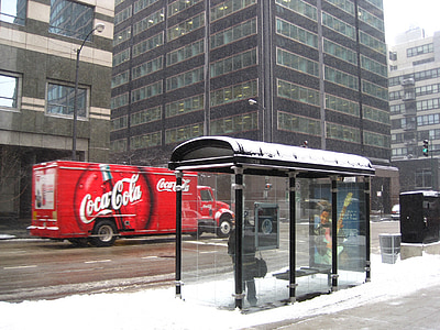 red Coca-Cola truck passing on gray high-rise building at daytime thumbnail
