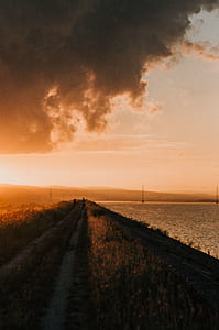 two person walking near ocean during daytime thumbnail