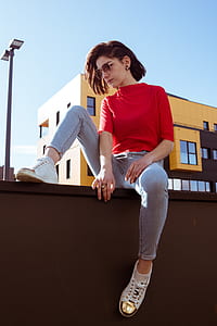 woman sitting near brown concrete building during daytime thumbnail