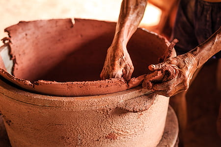 person holding brown clay pot thumbnail