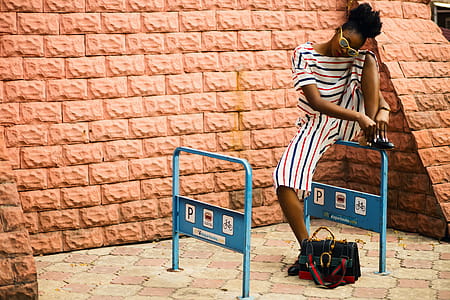 Woman With Striped Romper Sitting on Blue Metal thumbnail
