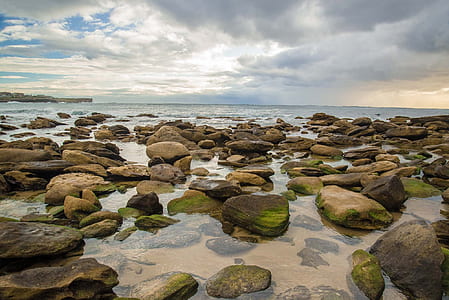 rocky shores under white cloudy sky thumbnail