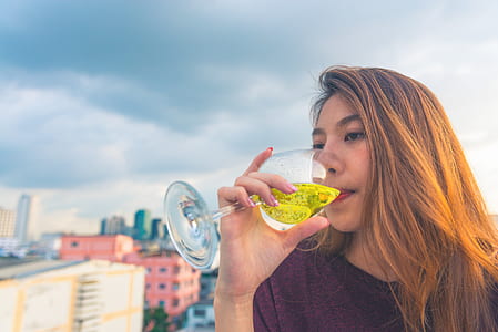 Woman in Purple Top Drinking on Clear Wine Glass thumbnail