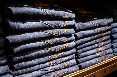blue denim bottoms on brown wooden rack thumbnail