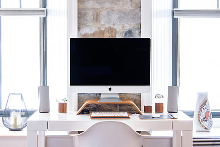 silver iMac turned off on white wooden table thumbnail