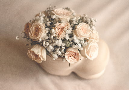 white and beige flowers on top of bed thumbnail