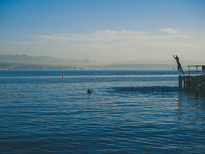 person jumping on dock at daytime thumbnail