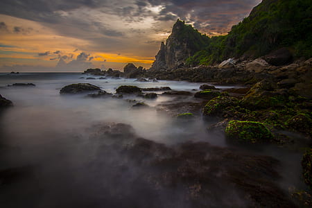rock by the water under golden hour thumbnail