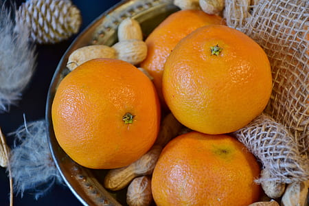 four orange fruits and nuts in bowl thumbnail