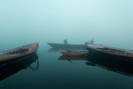 four brown boat on body of water thumbnail