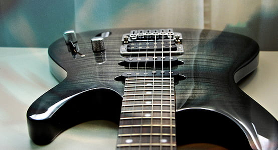 black electric guitar on table thumbnail