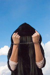 woman wearing black fur hoodie with both hand handcuffed thumbnail
