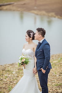 Groom and Bride Standing Near Body of Water thumbnail