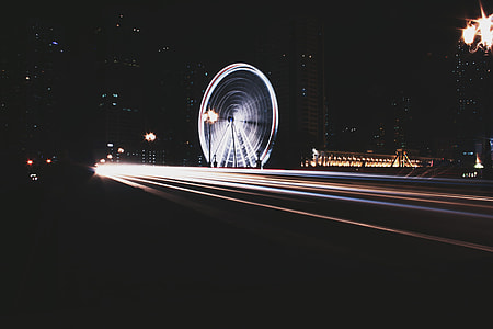 panning photo of road and Ferris wheel thumbnail