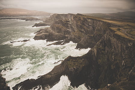 mountain cliff beside seashore during daytime thumbnail