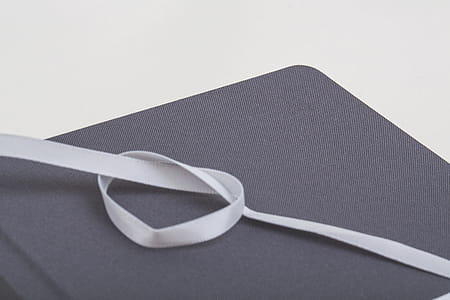 White Ribbon Formed Heart on Brown Rectangular Mat thumbnail