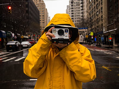 person holding Polaroid instant camera while taking photo thumbnail