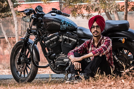 man sitting beside black standard motorcycle thumbnail