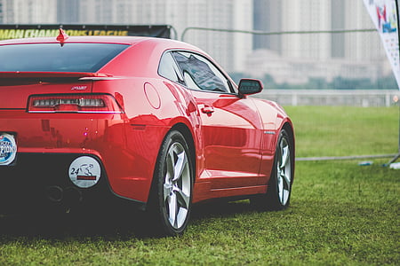 red coupe parked near signage thumbnail