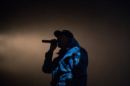 silhouette photography of man holding microphone thumbnail