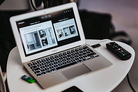 White laptop on a table with a remote thumbnail