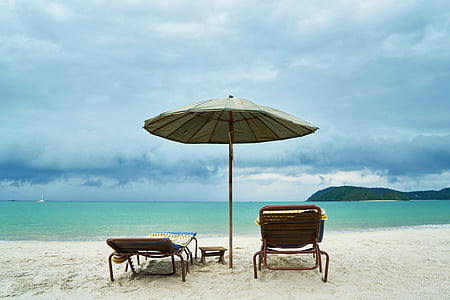 gray parasol near two sun loungers in shoreline near body of water thumbnail