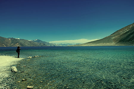 person standing near body of water during daytime thumbnail