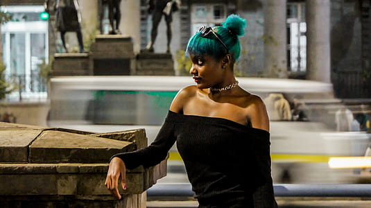 woman wearing black off-shoulder dress with green colored hair beside gray fence thumbnail