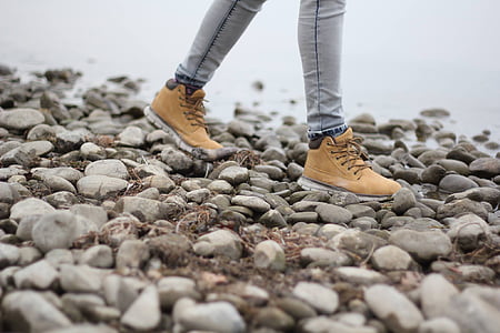 man standing on rocks near body of water thumbnail