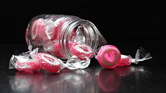clear mason jar filled with round pink candies thumbnail