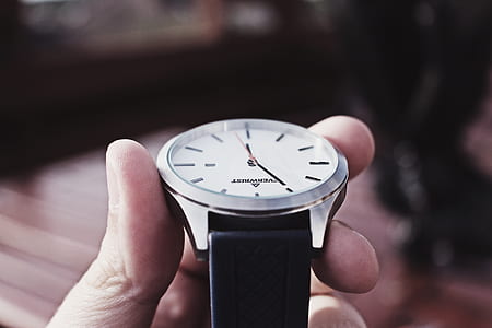 person holding round silver-colored watch at 6:55 thumbnail