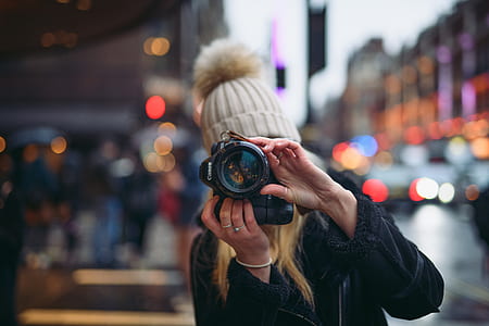 selective focus photo of woman holding camera thumbnail