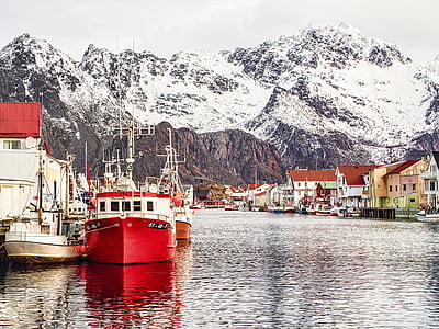 boat on body of water with snow-covered mountain view thumbnail