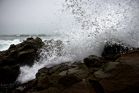 water crashing on brown rock at daytime thumbnail