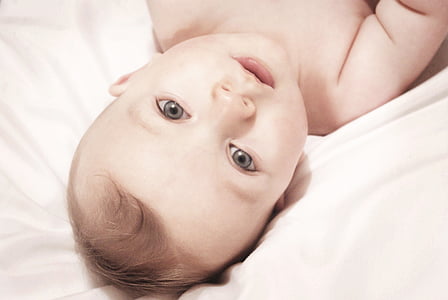 baby lying on white textile thumbnail