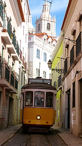 beige and white train between buildings thumbnail