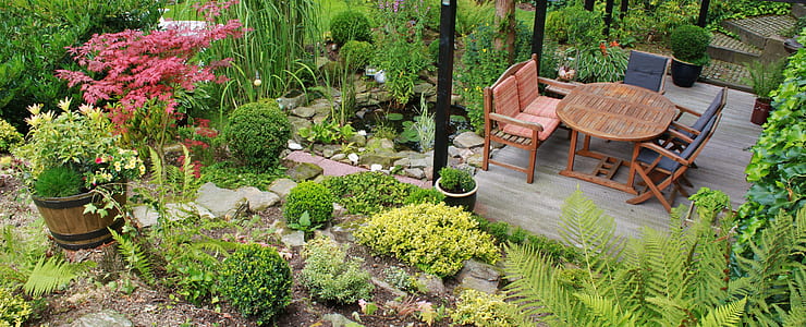 empty brown wooden chairs and table in the middle of garden thumbnail