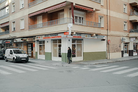 person walking towards pedestrian lane near building thumbnail