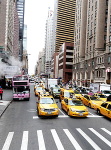 vehicles travelling on road between buildings at daytime thumbnail