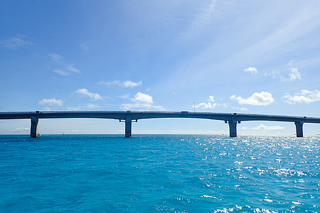 long gray concrete bridge surrounded by body of water thumbnail