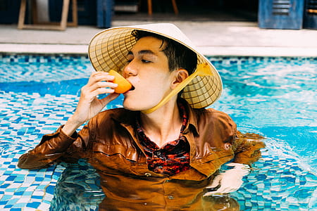 man wearing brown dress shirt in pool during daytime thumbnail