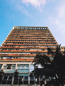 brown concrete building under blue sky thumbnail