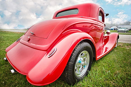 red classic car park on green grass thumbnail