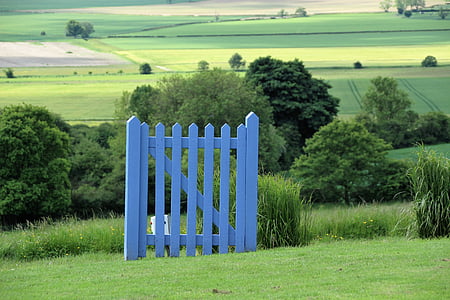 blue wooden fence on grass field during daytime thumbnail
