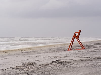 red metal ladder beside seashore thumbnail