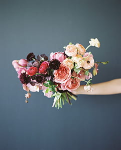 person holding assorted-color flowers thumbnail